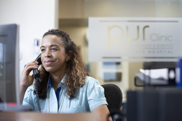 Receptionist on the phone at the Pur Clinic